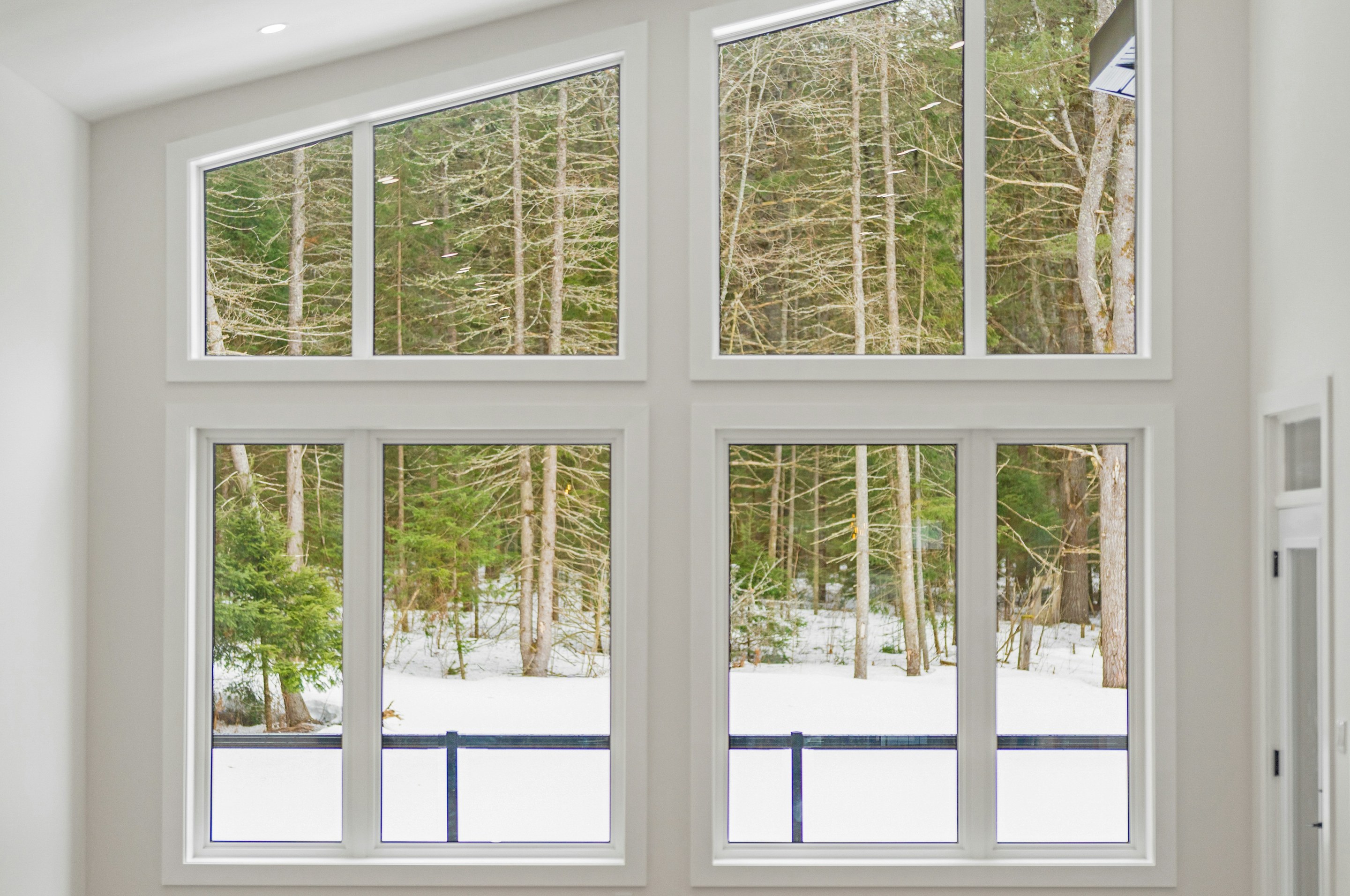 Bright room with tall windows looking onto a snowy forest, glass perfectly clear with LUNOX Anti-Fog/Frost Film